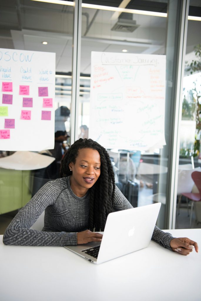 Confident woman working on laptop at modern indoor office desk.