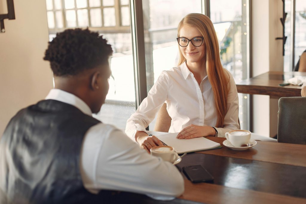 Two professionals engaged in a friendly business meeting in a stylish office setting.