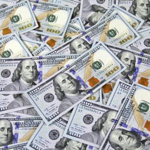 Pile of US hundred dollar bills depicting financial success and wealth.