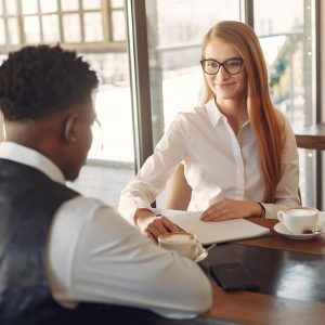Two professionals engaged in a friendly business meeting in a stylish office setting.
