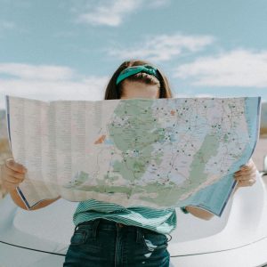 A woman holds a map while traveling through the scenic desert of California, USA.