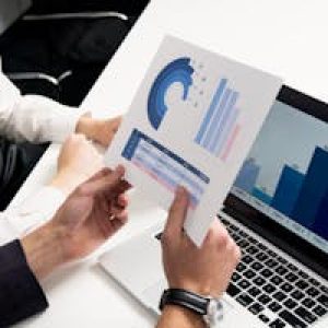 Business professionals discussing data charts and graphs in a modern office setting.