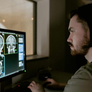 Radiologist examining a CT scan on a monitor in a medical facility.